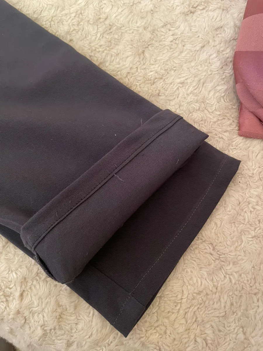 Close-up of a neatly finished turn-up on a pair of dark trousers